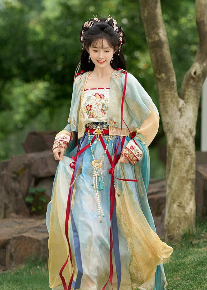 Woman in traditional Hanfu attire standing outdoors with greenery in the background